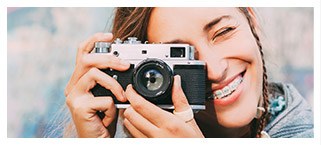 Young woman with braces looking through camera lens